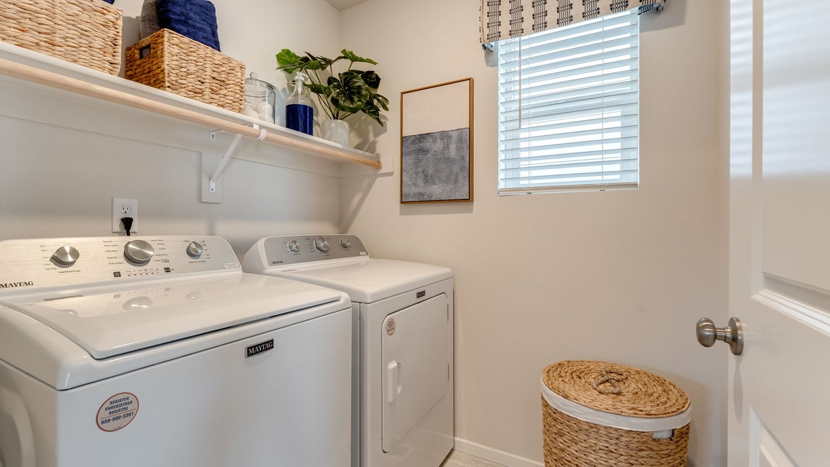 Laundry room with built-in shelves and washer and dryer hookups
