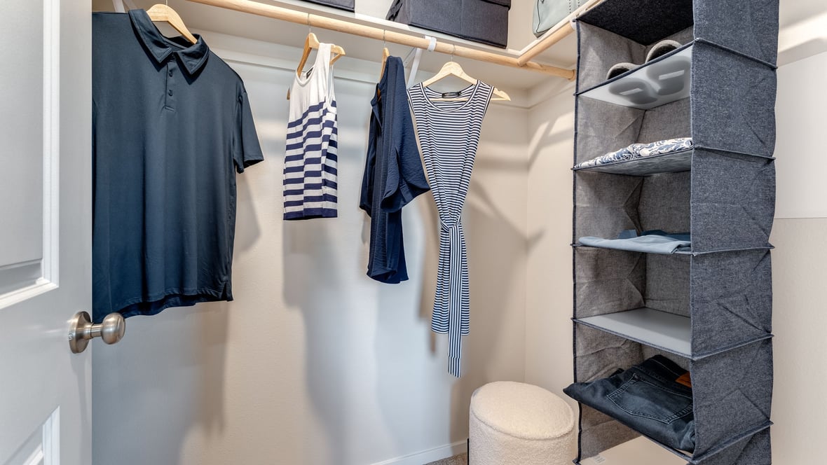 Primary bedroom walk-in closet with built-in shelves