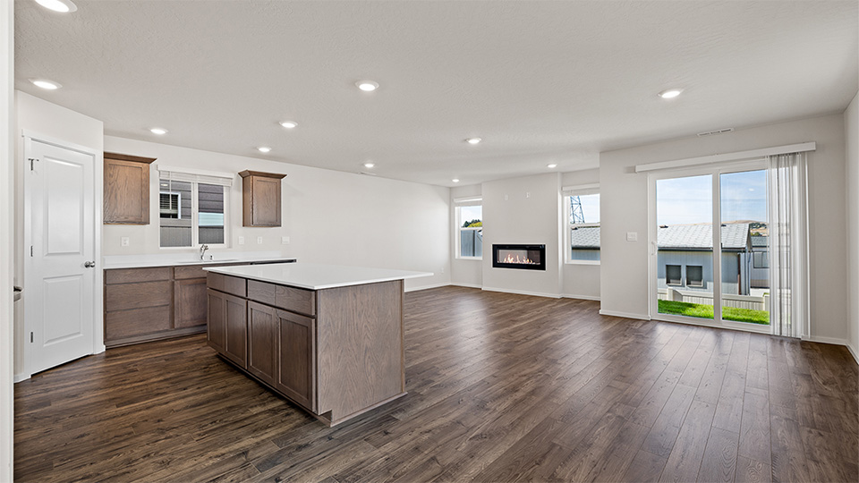 Kitchen with shaker cabinets, quartz counters, stainless steel appliances, pantry, and an island with a breakfast bar