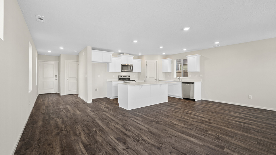 Kitchen with shaker cabinets, quartz counters, stainless steel appliances, pantry, and an island with a breakfast bar
