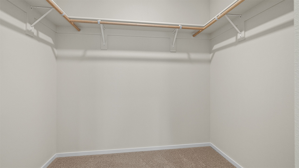 Primary bedroom walk-in closet with built-in shelves