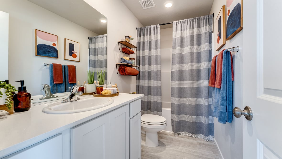 Hall bathroom with combination tub/shower and quartz counters
