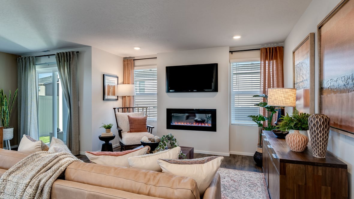 great room with an electric fireplace, vaulted ceilings, and premium laminate flooring