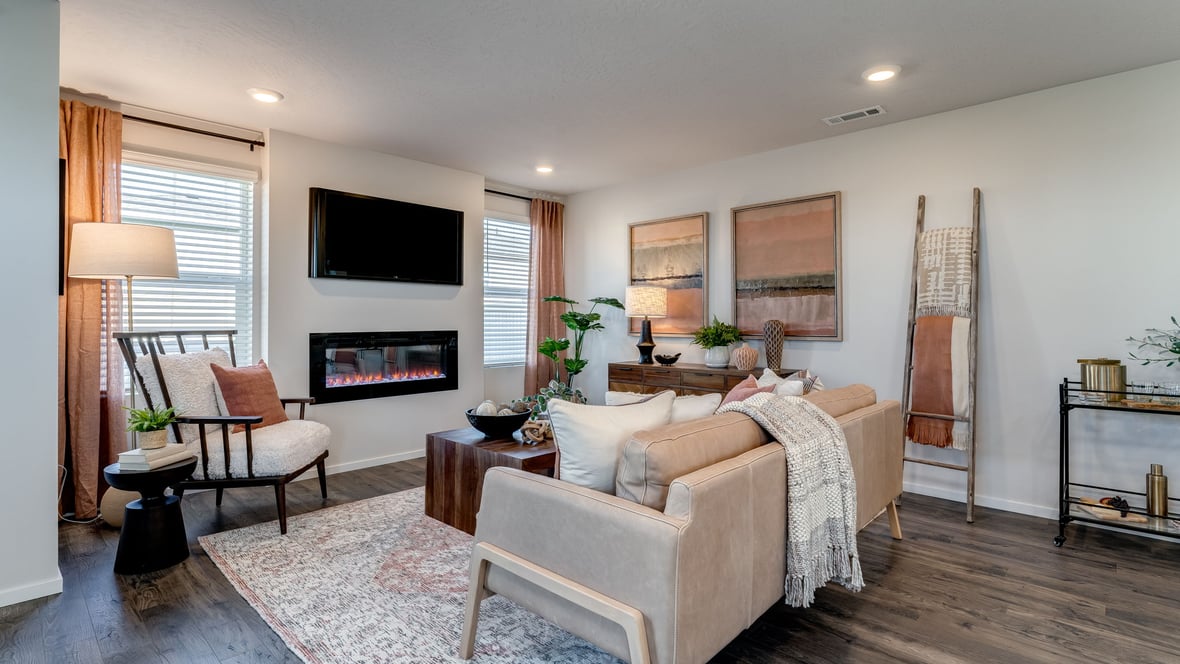 great room with an electric fireplace, vaulted ceilings, and premium laminate flooring