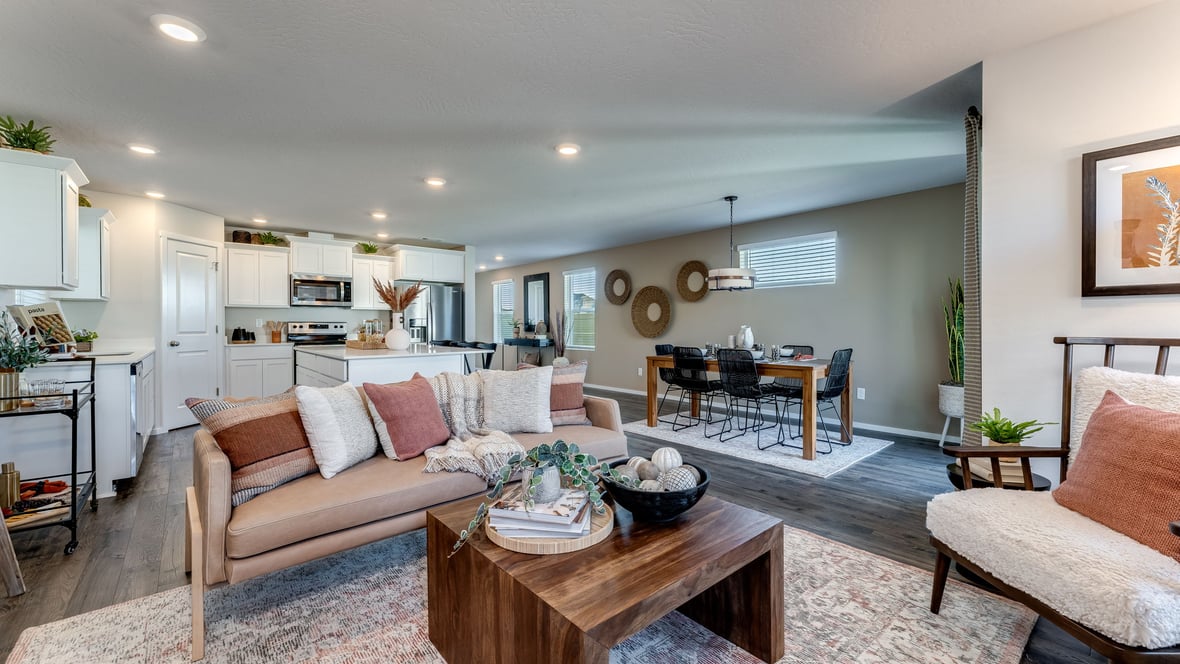 great room with an electric fireplace, vaulted ceilings, and premium laminate flooring