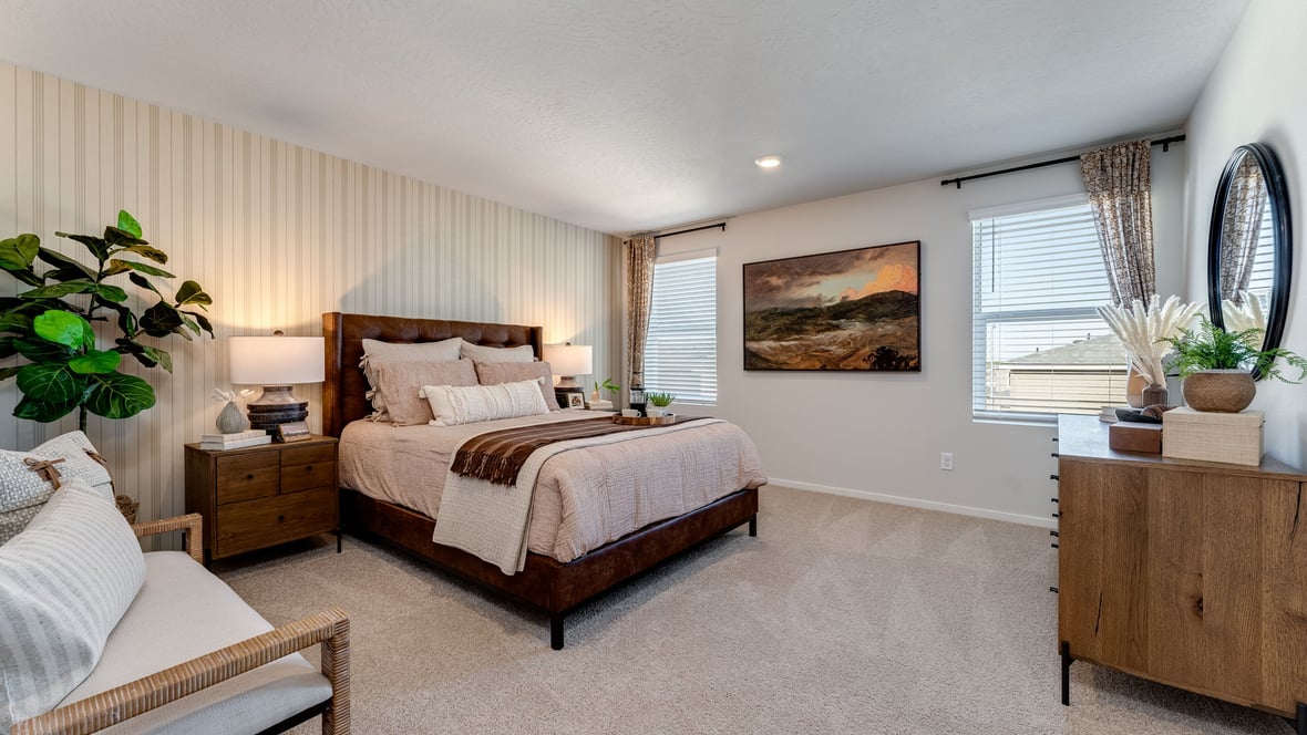 primary bedroom with wall-to-wall carpet, queen sized bed, and large dresser