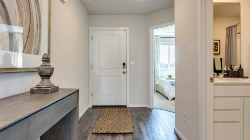 An entryway with premium laminate flooring, main level bedroom, and a full bathroom on the lower level.