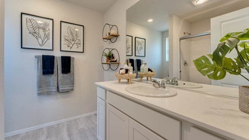 primary bathroom with a walk-in shower with bench seats, white quartz countertops, and a large vanity