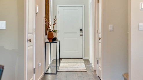 entry with a white front door and premium laminate flooring