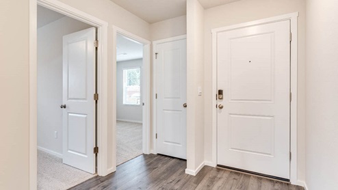 An entryway with premium laminate flooring, main level bedroom, and a full bathroom on the lower level.
