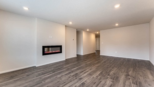 Great great room with an electric fireplace, vaulted ceilings, and premium laminate flooring