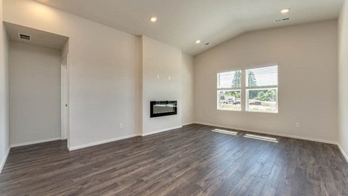 great room with an electric fireplace, vaulted ceilings, and premium laminate flooring