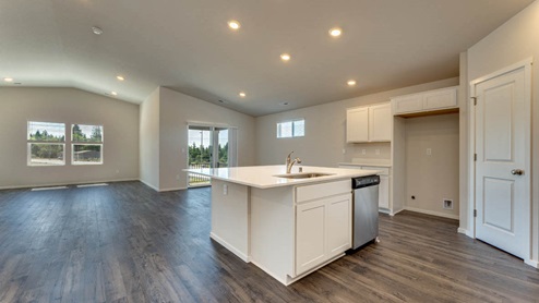 main floor with vaulted ceilings and premium laminate floors. Open floor plan with kitchen, dining, and living areas.