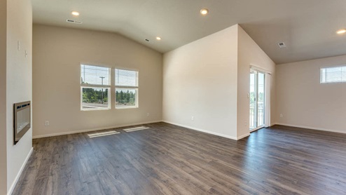 great room with an electric fireplace, vaulted ceilings, and premium laminate flooring