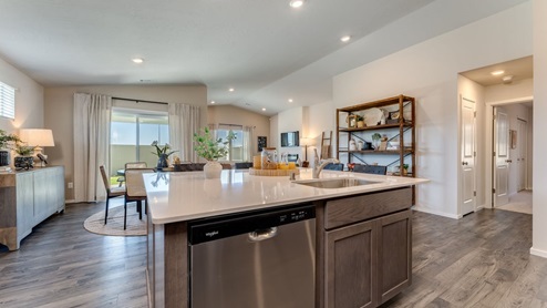 Kitchen with shaker cabinets, quartz counters, stainless steel appliances, pantry, and an island with a breakfast bar