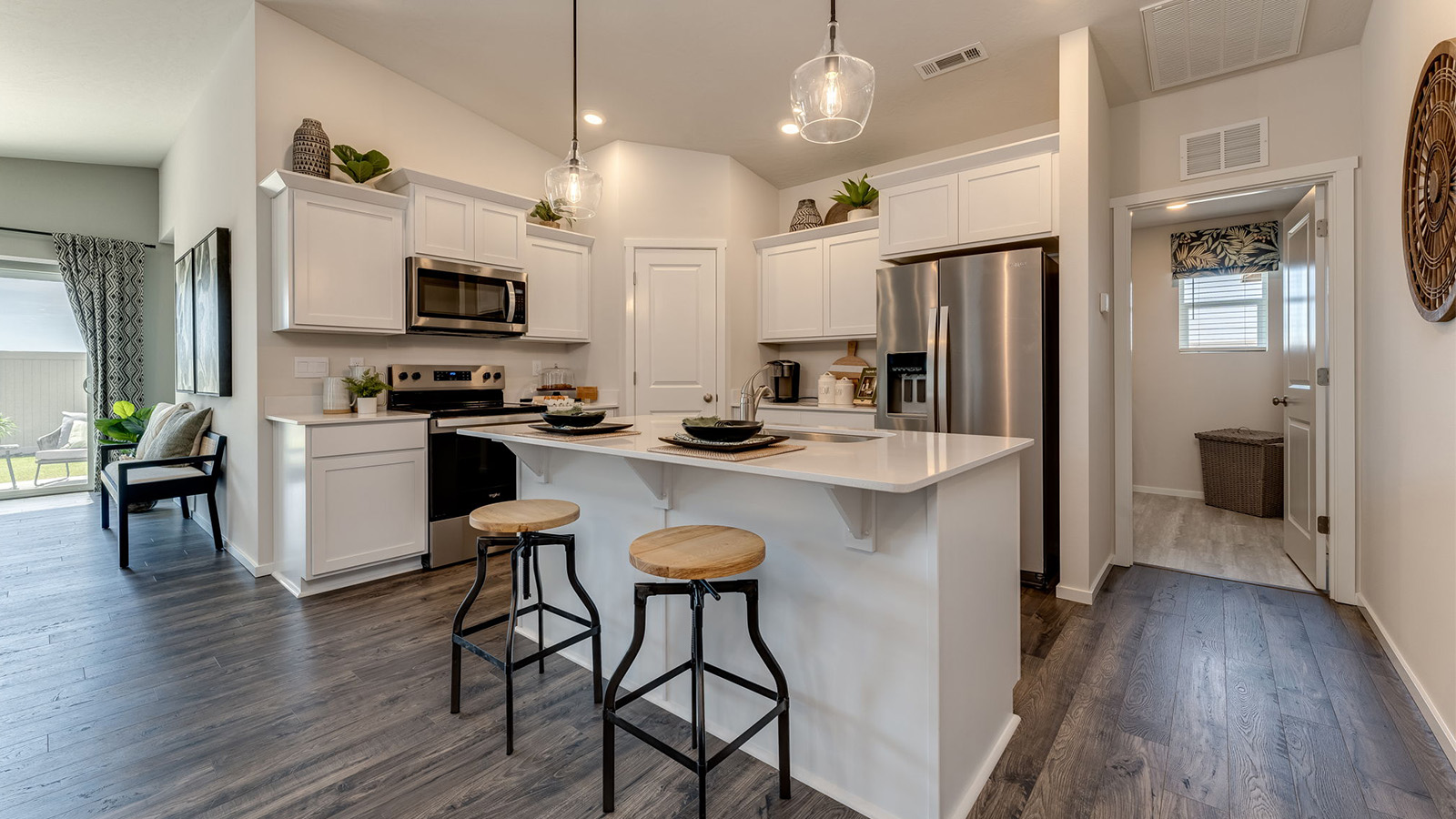 Kitchen with shaker cabinets, quartz counters, stainless steel appliances, pantry, and an island with a breakfast bar