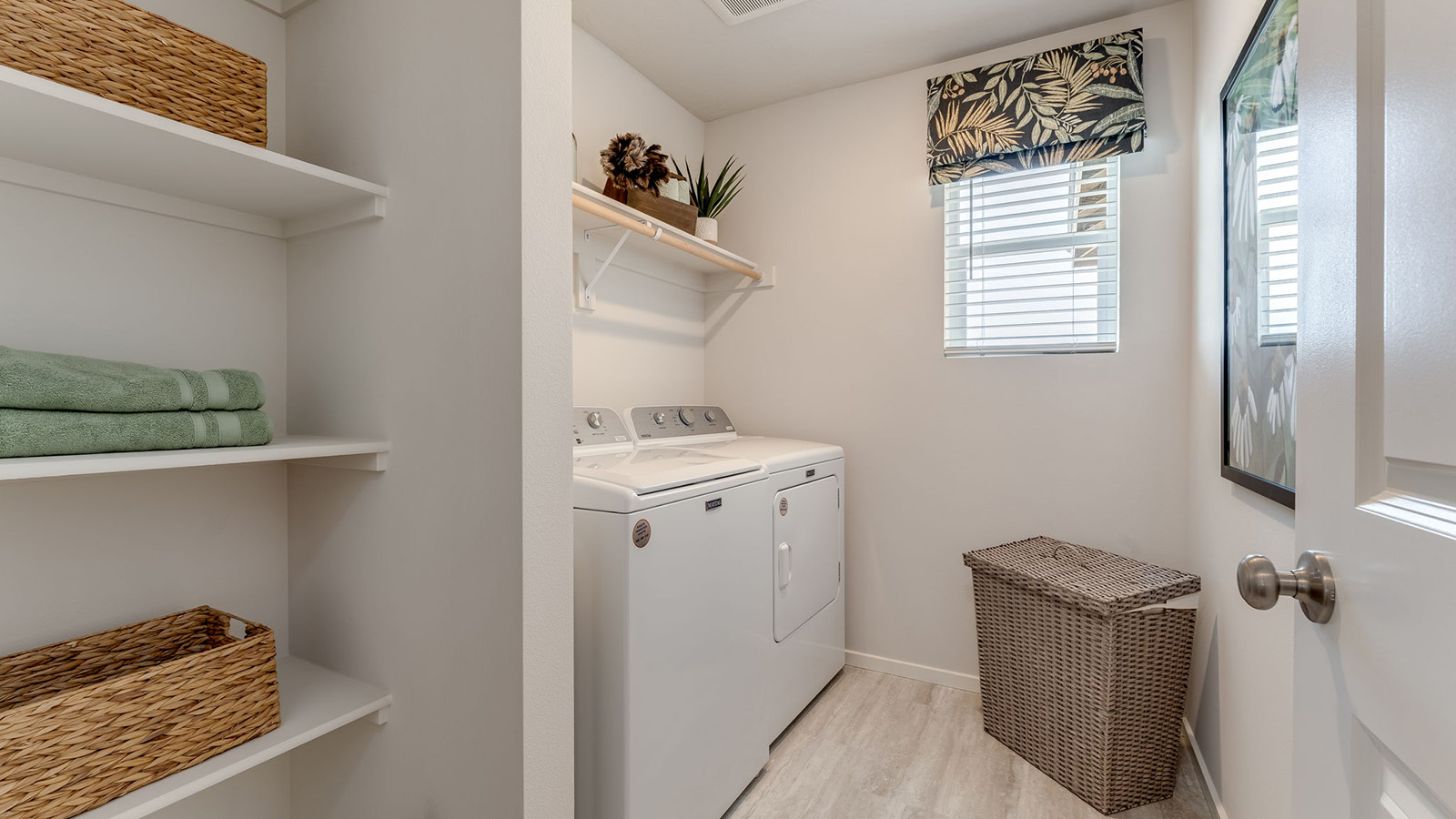 Laundry room with built-in shelves and washer and dryer hookups
