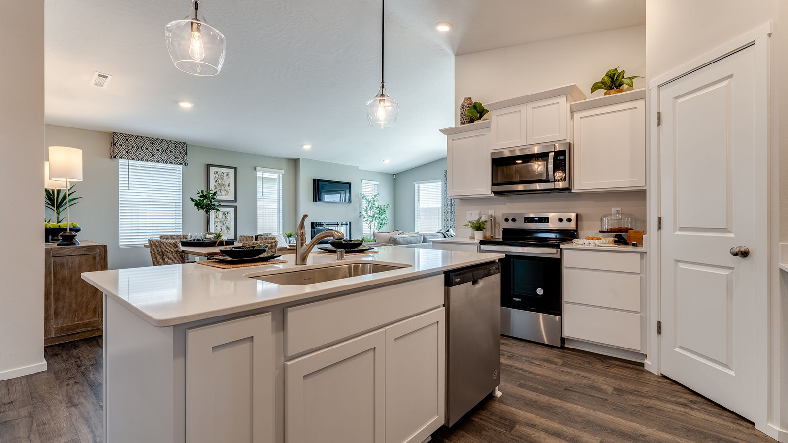 Kitchen with shaker cabinets, quartz counters, stainless steel appliances, pantry, and an island with a breakfast bar
