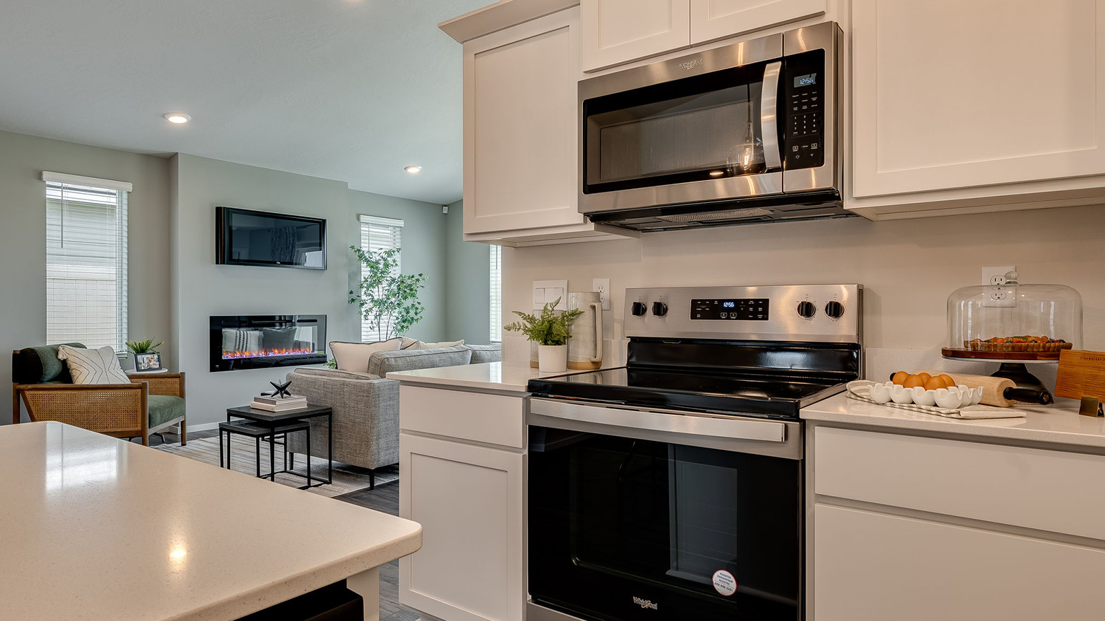 Kitchen with shaker cabinets, quartz counters, stainless steel appliances, pantry, and an island with a breakfast bar
