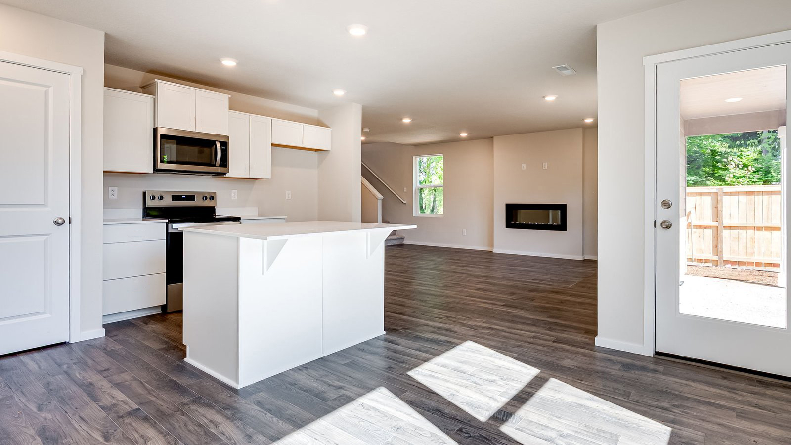 Kitchen with shaker cabinets, quartz counters, stainless steel appliances, pantry, and an island with a breakfast bar