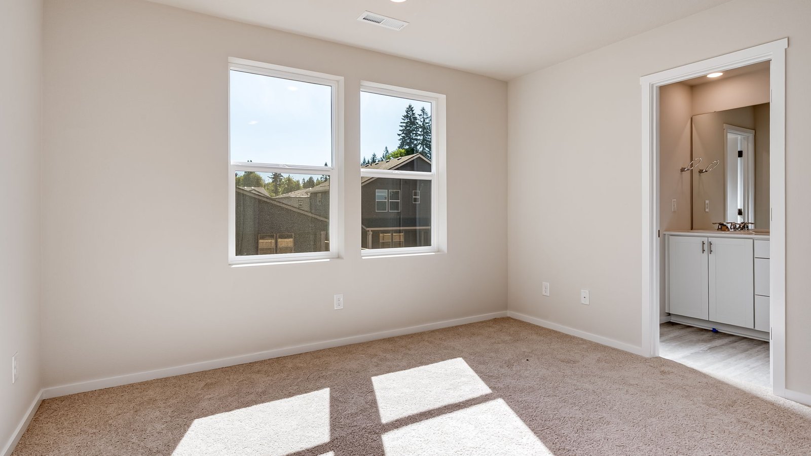Primary bedroom with wall-to-wall carpet, a walk-in closet and an attached bathroom
