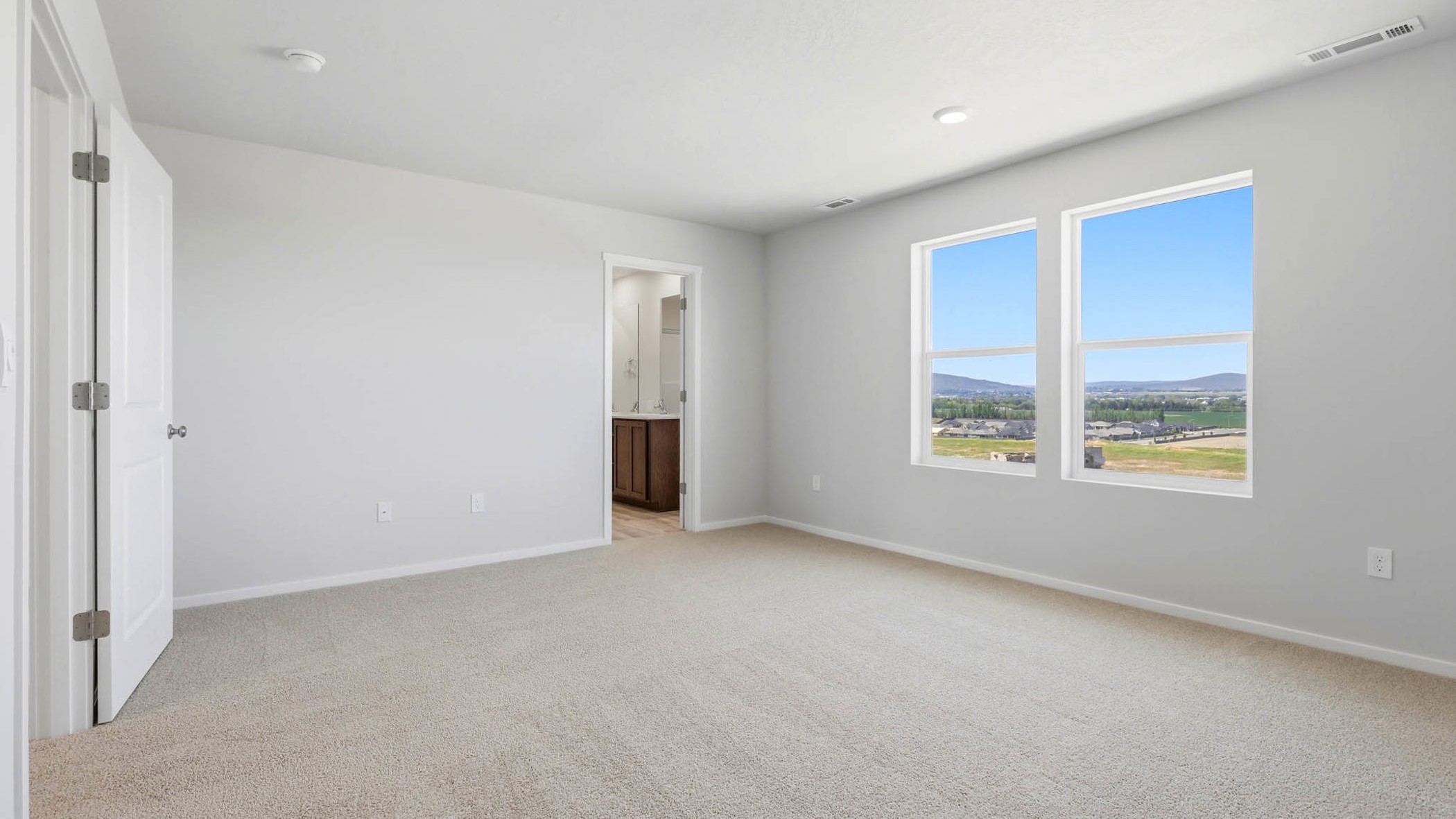 Primary bedroom with wall-to-wall carpet, a walk-in closet and an attached bathroom