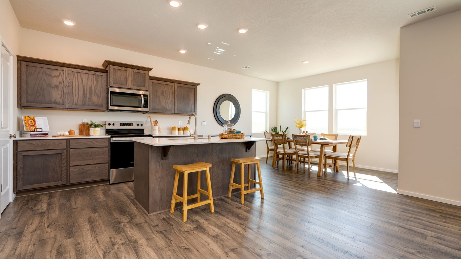 Kitchen with shaker cabinets, quartz counters, stainless steel appliances, pantry, and an island with a breakfast bar