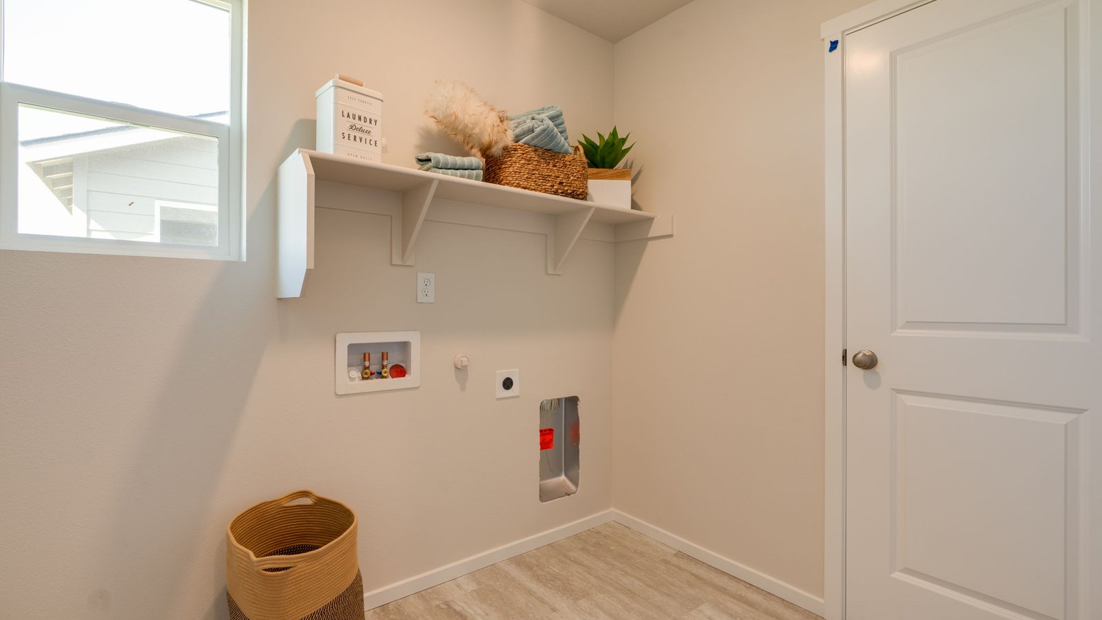 Laundry room with built-in shelves and washer and dryer hookups