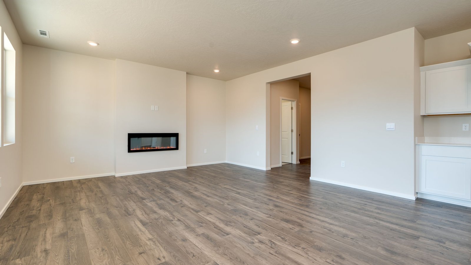 Great room with laminate flooring and an electric fireplace