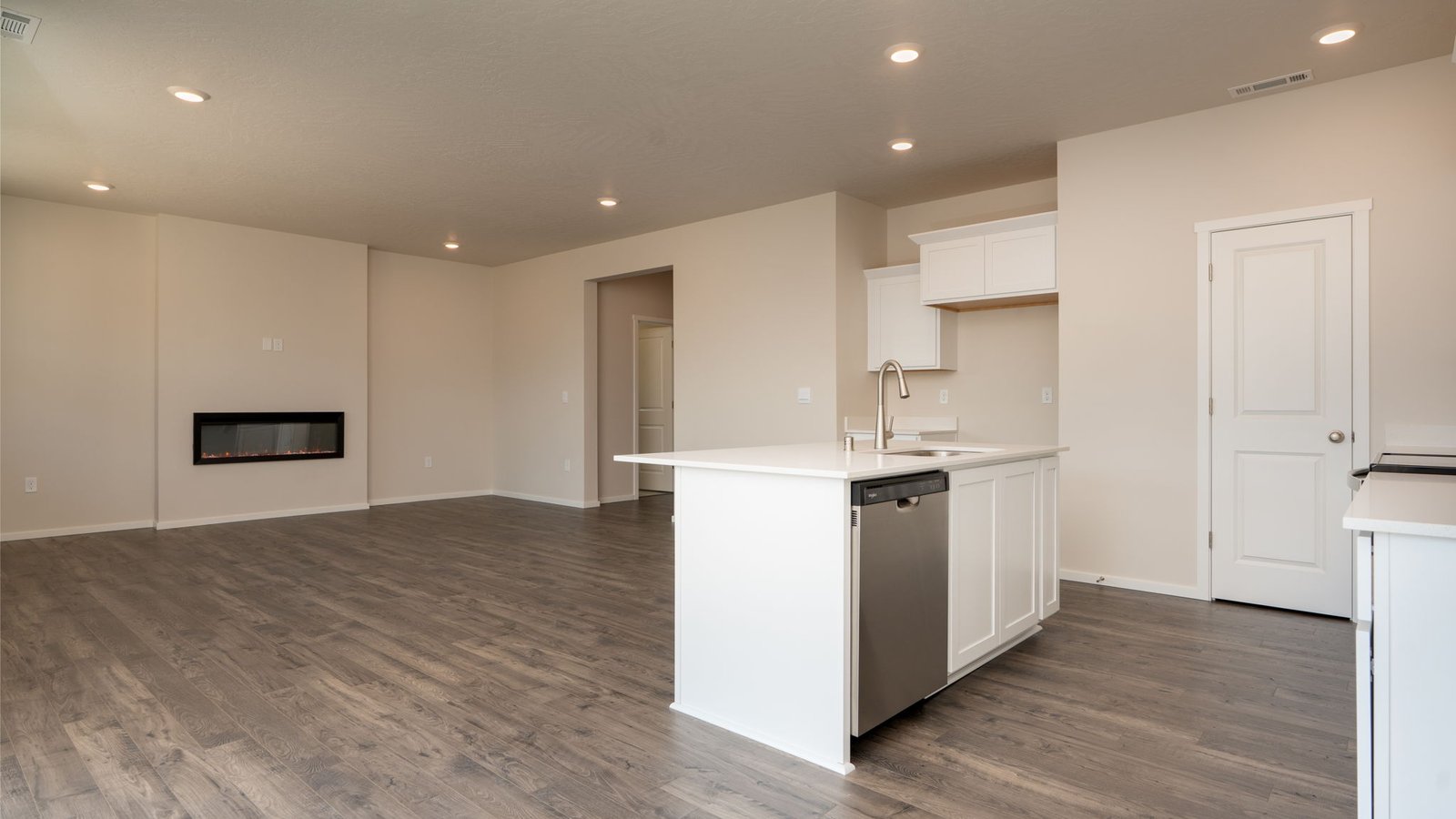 Kitchen with shaker cabinets, quartz counters, stainless steel appliances, pantry, and an island with a breakfast bar