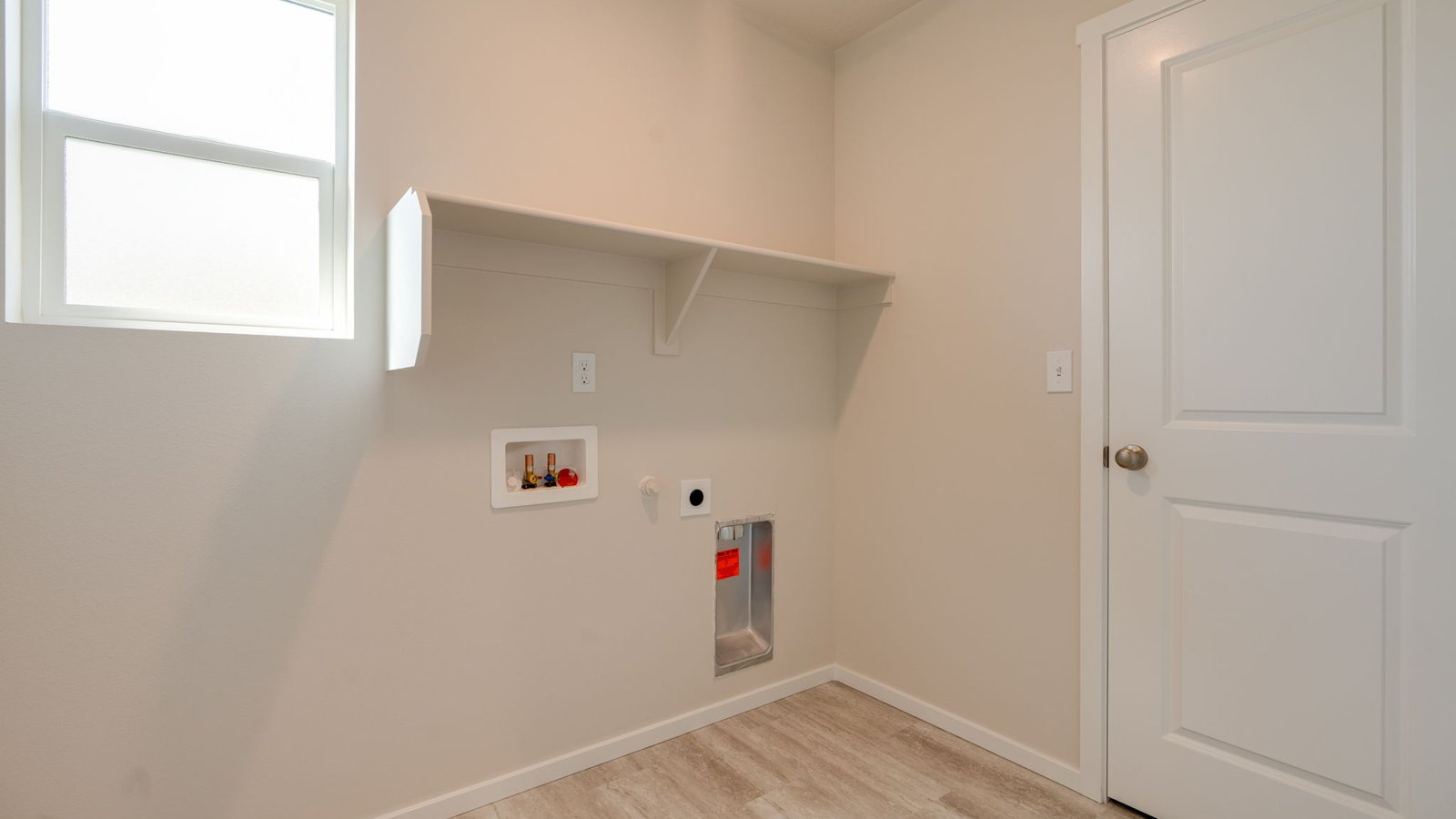 Laundry room with built-in shelves and washer and dryer hookups