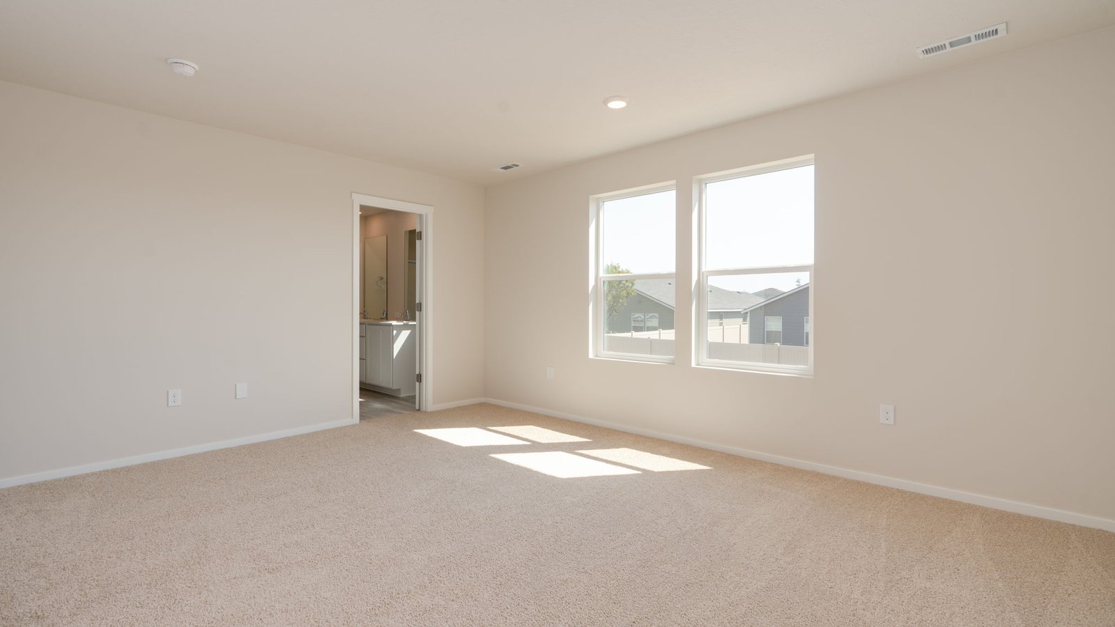 Primary bedroom with wall-to-wall carpet, a walk-in closet and an attached bathroom