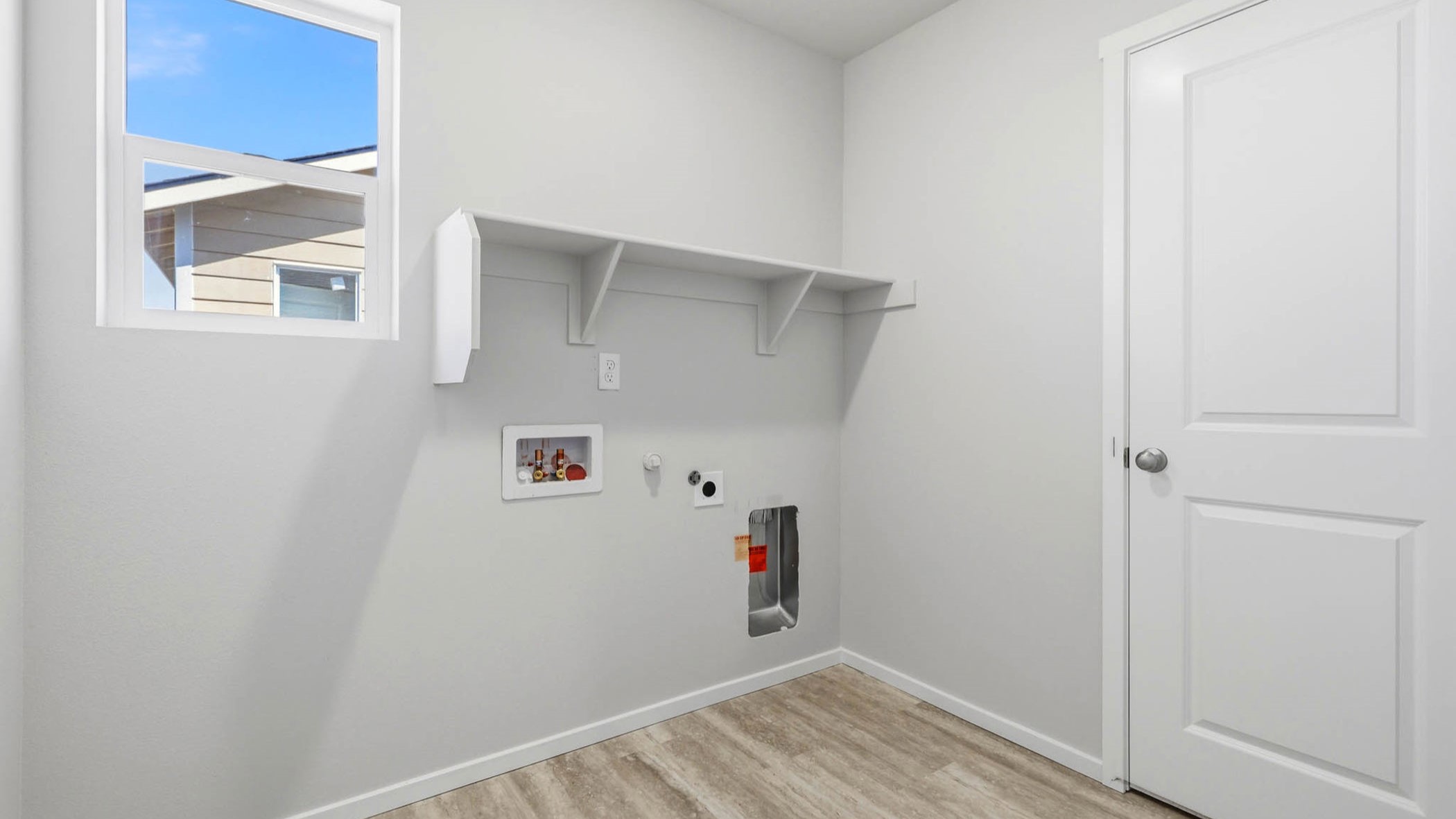 Laundry room with built-in shelves and washer and dryer hookups