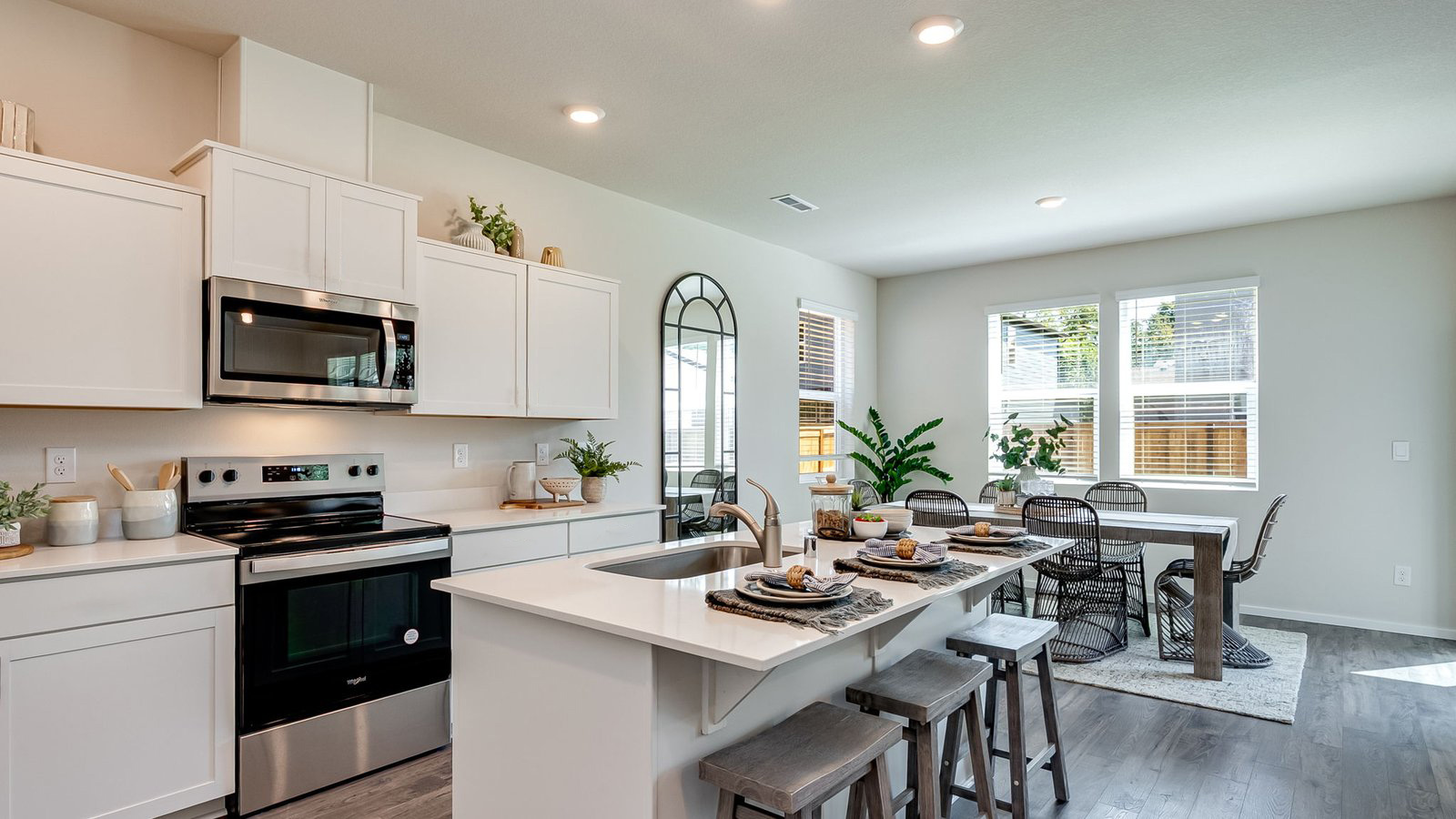 Kitchen with shaker cabinets, quartz counters, stainless steel appliances, pantry, and an island with a breakfast bar