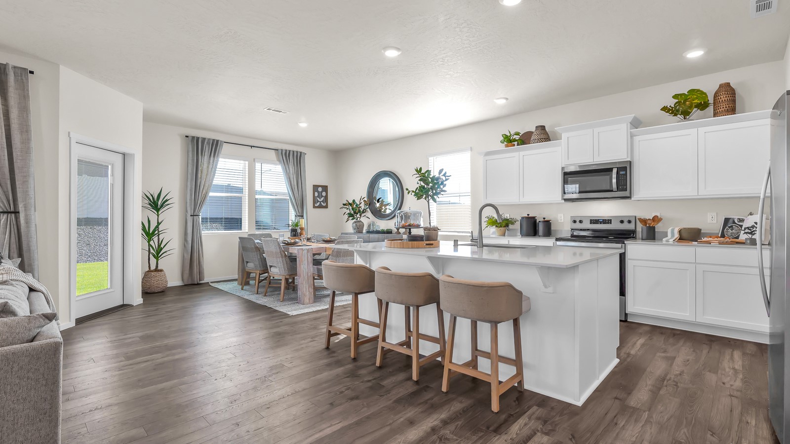 Kitchen with shaker cabinets, quartz counters, stainless steel appliances, pantry, and an island with a breakfast bar
