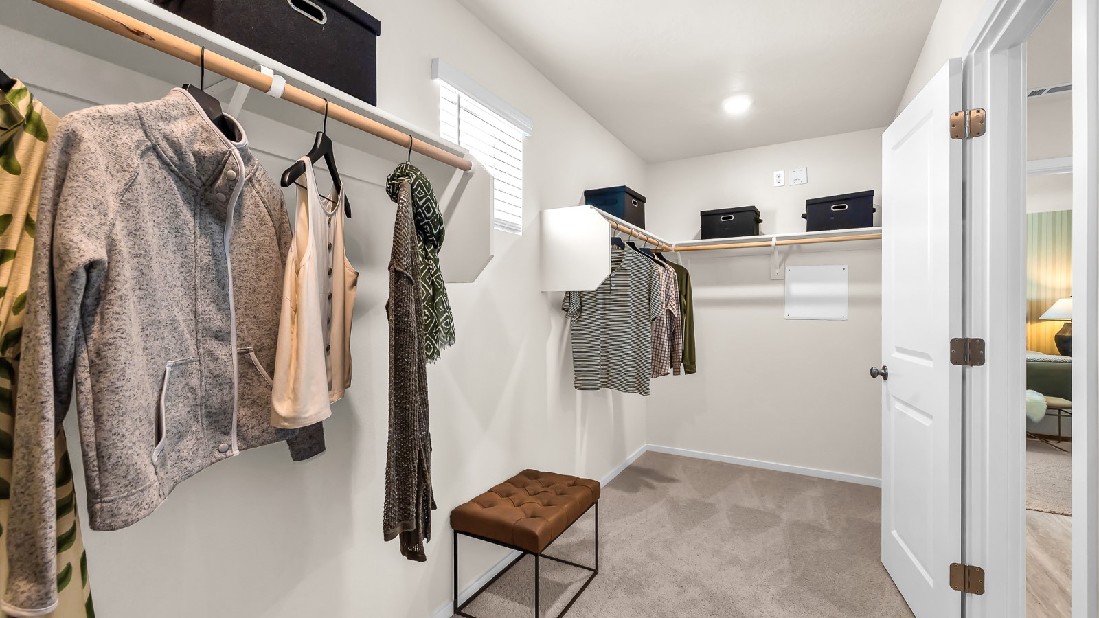 Primary bedroom walk-in closet with built-in shelves