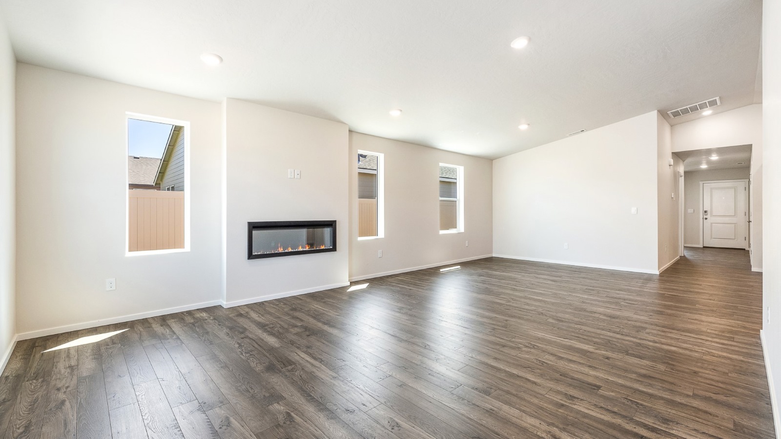 Great room with laminate flooring and an electric fireplace and vaulted ceilings