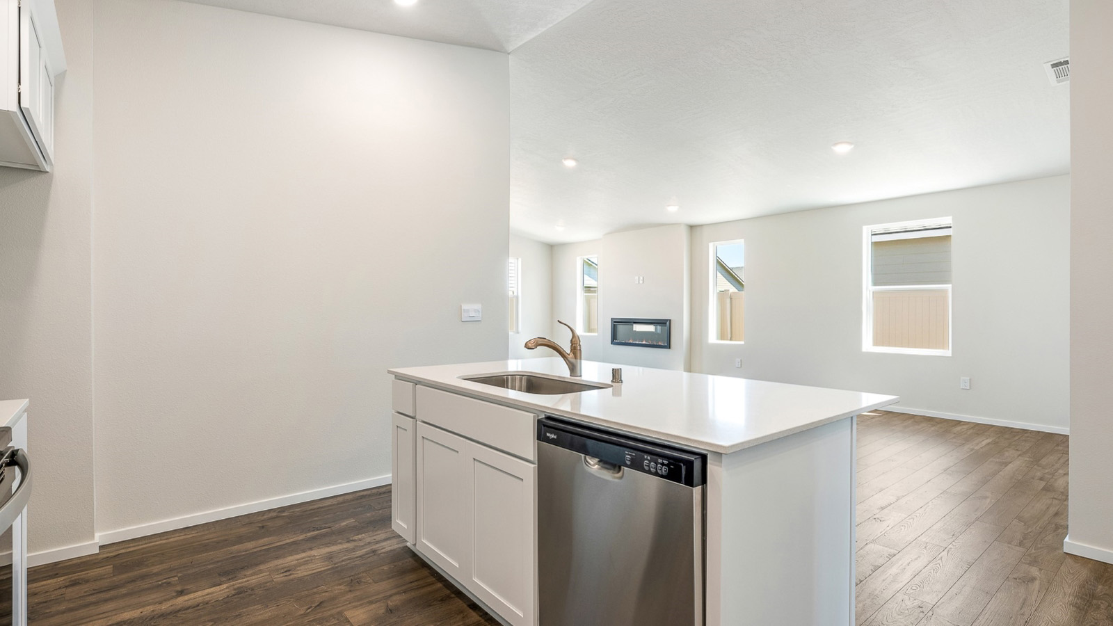 Kitchen with shaker cabinets, quartz counters, stainless steel appliances, pantry, and an island with a breakfast bar