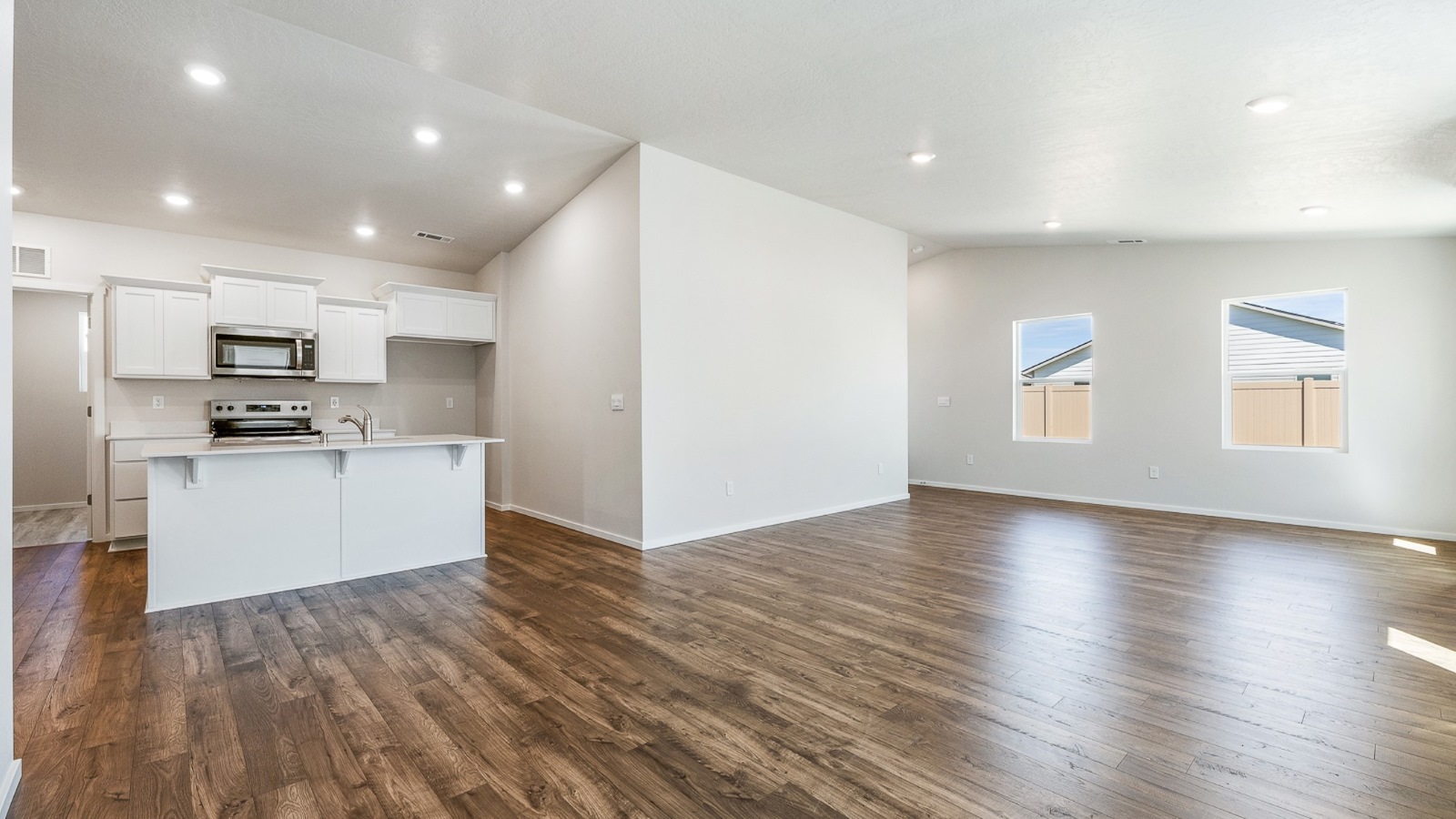 Great room with laminate flooring and an electric fireplace and vaulted ceilings