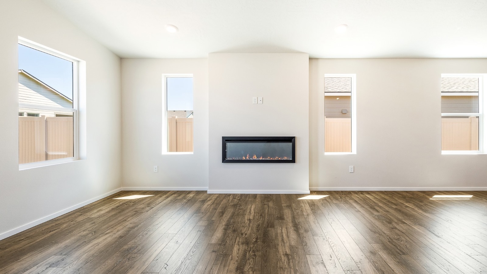 Great room with laminate flooring and an electric fireplace and vaulted ceilings