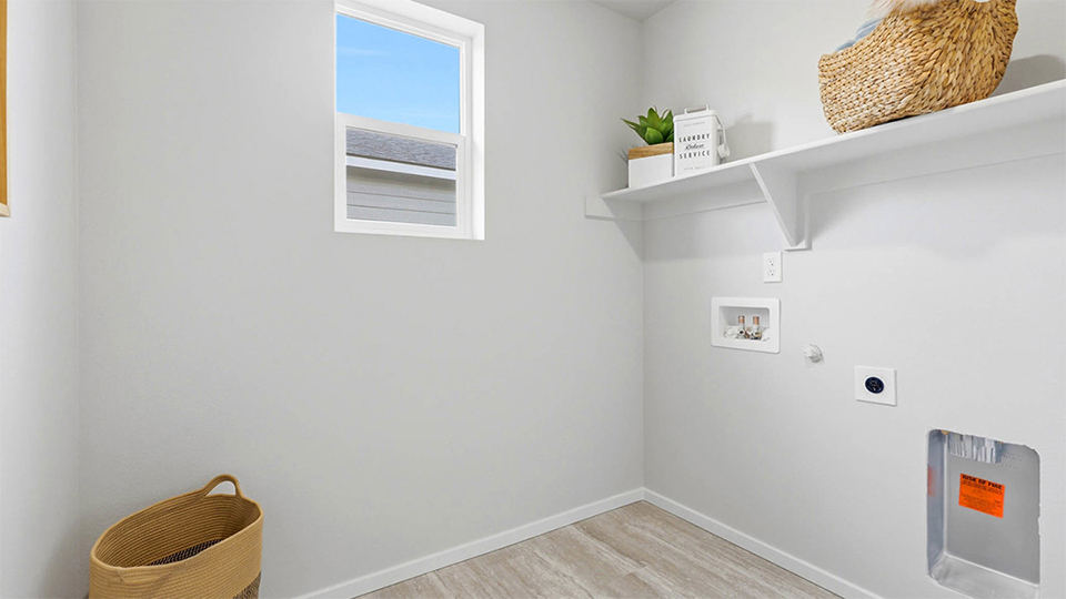 Laundry room with built-in shelves and washer and dryer hookups