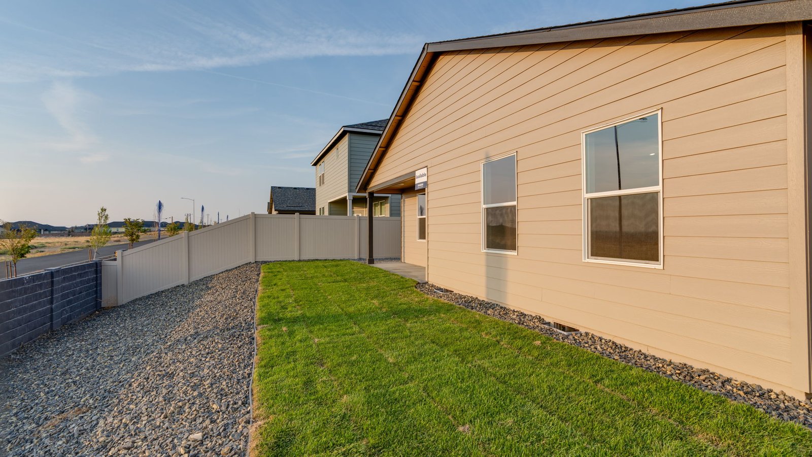 fully fenced backyard with sod lawn and a patio