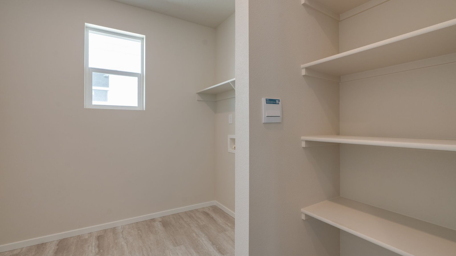 Laundry room with built-in shelves and washer and dryer hookups