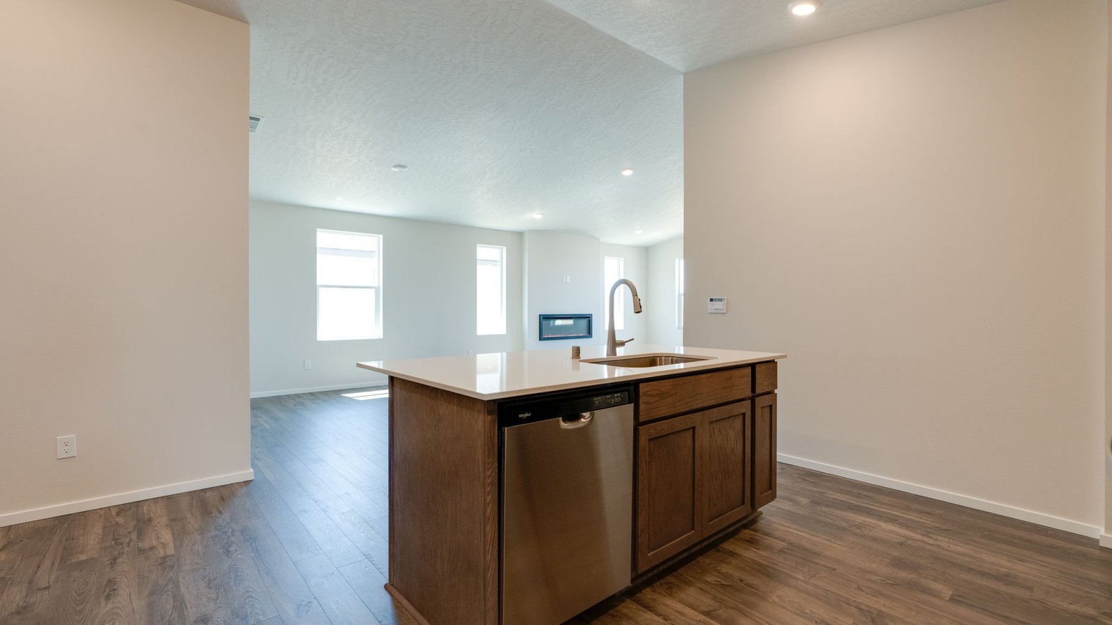 Kitchen with shaker cabinets, quartz counters, stainless steel appliances, pantry, and an island with a breakfast bar