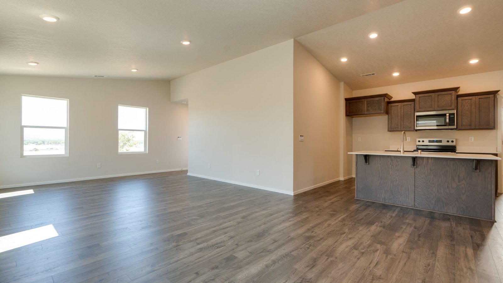 Great room with laminate flooring and an electric fireplace and vaulted ceilings