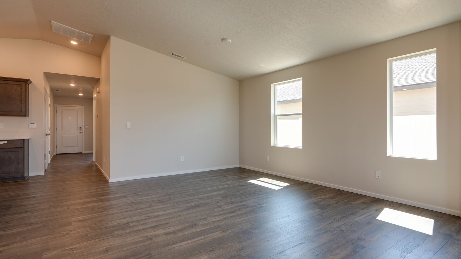 Great room with laminate flooring and an electric fireplace and vaulted ceilings