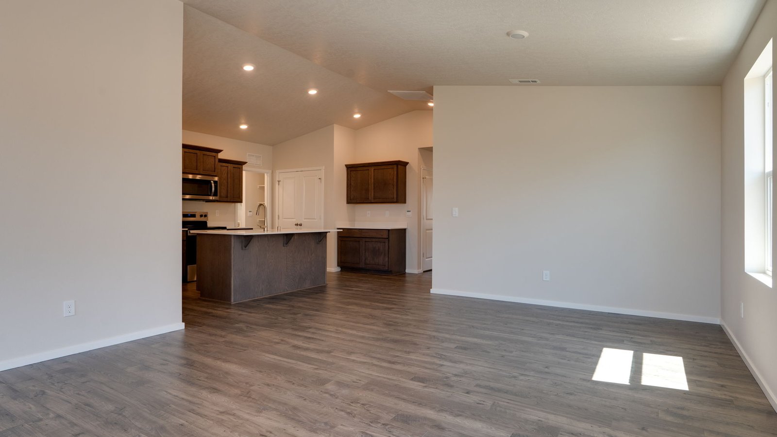 Great room with laminate flooring and an electric fireplace and vaulted ceilings