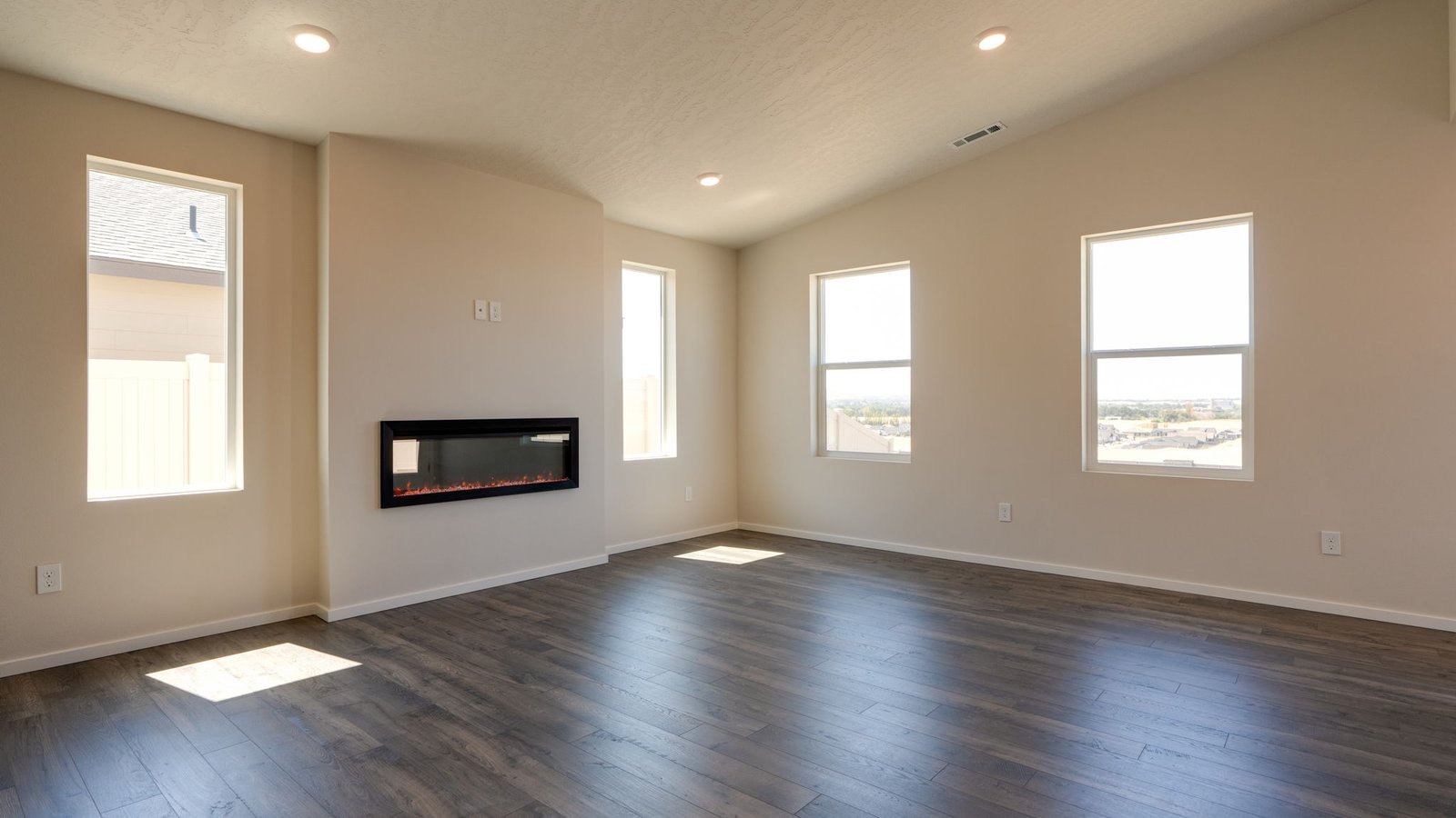 Great room with laminate flooring and an electric fireplace and vaulted ceilings