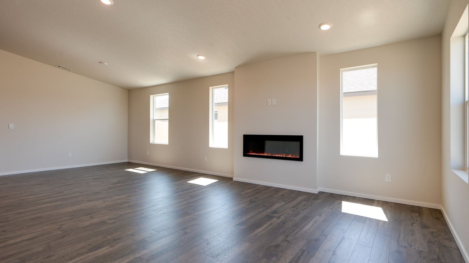 Great room with laminate flooring and an electric fireplace and vaulted ceilings