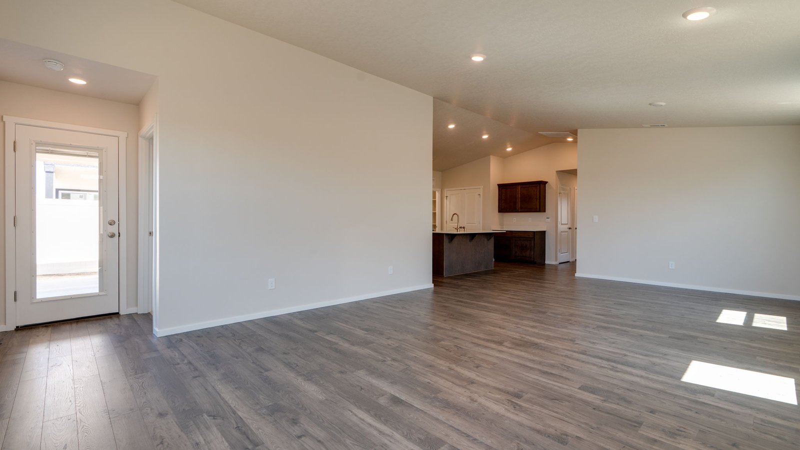 Great room with laminate flooring and an electric fireplace and vaulted ceilings